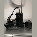 Černý bezdrátový mikrofonní systém značky AKG. Na přijímači je nápis SR 40 STATIONARY RECEIVER a MINI PRO, na vysílači MINI PRO PT 40. Soubor obsahuj…