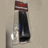 Černý obdélníkový blok s povrchem imitujícím karbonová vlákna, zabalený v průhledném plastovém sáčku. Na kartonové vložce je nápis SHRED NECK a pod n…