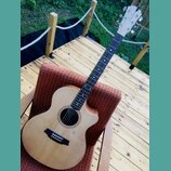 Akustická kytara s vyřezem (cutaway) v přirozené dřevěné barvě. Na hlavě je viditelné logo "Cu Artisan". Hmatník je tmavý s bílými polohovými značkam…