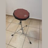 Osmiboký bubeníkářský židličkový stolek s červeným sedákem a černým okrajem. Na povrchu sedáku je bílé logo MAPEX. Nohy jsou kovové, teleskopické a z…