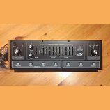 Černý syntezátor s nápisy behringer a Toro. Přístroj obsahuje několik otočných knoflíků, posuvníků a tlačítek s označením jako VOLUME, FILTER, TUNE n…