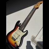 Elektrická kytara s telym v provedení sunburst a bílým pickguardem. Na hlavě hředu je viditelné logo Fender. Nástroj má tři snímače, pětistupňový pře…