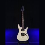 Bílá elektrická kytara s dvojstupňovitým tělem a tmavým hmatníkem. Nástroj má dva humbuckery, jeden ovládací knoflík hlasitosti a jeden tón. Na hlavě…