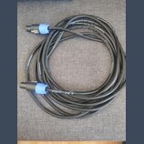 Černý audio kabel s modrými konektory na koncích. Na povrchu kabelu je bílý nápis Adam Hall GmbH a adresa adamhall.com. Kabel je svinut do několika s…