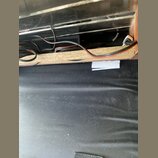 Detailní pohled na vnitřek šasi nebo skříně s viditelným zapojením černých kabelů. Součástí je dřevěná deska z OSB a v pozadí jsou vidět elektronické…