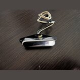 Na fotografii je vidět chromovaný harmonikový mouthpiece s černým plastovým základem. K nástroji je přivázán světlý šňůrek. Povrch chromu vykazuje dr…