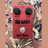 Červený kytarový efekt s nápisy RED LLAMA, OVERDRIVE MkIII a WAY HUGE. Na horní straně jsou dva černé otočné knoflíky s popisky VOLUME a DRIVE, modrá…