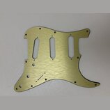 Zlatý kovový pickguard pro elektrickou kytaru s broušeným povrchem. Má tři oválné výřezy pro snímače a několik malých otvorů na šrouby. Na povrchu ne…