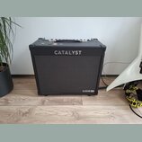 Černý kytarový kombo zesilovač s látkovou mřížkou. Na přední straně je nápis CATALYST a v pravém dolním rohu logo LINE 6. Horní strana obsahuje úchyt…