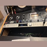 Na fotografii jsou dvě rackové jednotky v černém a stříbrném provedení. Horní černý přístroj nese nápisy WARM AUDIO a LA76 LIMITING AMPLIFIER s někol…