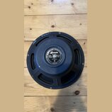 Zadní strana černého reproduktoru s kovovým rámem. Uprostřed magnetu je štítek s nápisy: JENSEN INDUSTRIES - SPEAKERS DIVISION, Jensen, Alnico Magnet…