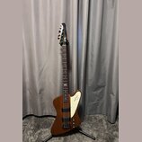 Hnědá elektrická basová kytara s bílým plechtrátorem. Na hlavě je viditelné logo Rickenbacker a na plechtrátoru je nápis Rickenbacker s doprovodným l…