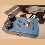 Modrý kytarový efekt s nápisy MXR a blue box. Na horní straně jsou dva černé otočné knoflíky s popisky BLEND a OUTPUT, červená kontrolka a kovový spí…