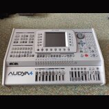 Stříbrný aranžér Ketron Audya 4 s nápisem „AUDYA 4 advanced music station“ v levém dolním rohu a logem „KETRON“ nahoře. Přístroj disponuje LCD disple…