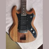 Elektrická kytara s přírodním dřevěným povrchem a černým pickguardem. Nástroj má dva humbuckery, dvě otočné potenciometry a jeden přepínač. V dolní č…