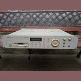 Bílý rackový MIDI sampler s nápisem AKAI professional MIDI STEREO DIGITAL SAMPLER S2000. Přední panel obsahuje floppy disketovou mechaniku, LCD displ…