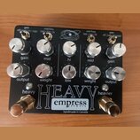 Černý kytarový efekt s nápisem HEAVY a logem empress effects. Na spodní straně je text handmade in Canada. Zařízení má deset stříbrných otočných knof…