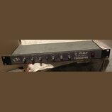 Černý rackový přístroj s nápisem 2 WAY STEREO CROSSOVER a logem AUDIOMAX. Na předním panelu se nachází šest otočných ovířkovaných potenciometrů s pop…