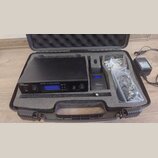 Černý kufr s pěnovou výplní obsahuje vysílač a přijímač in-ear monitoringu. Na vysílači je nápis „the t.bone IEM100T UHF STEREO TRANSMITTER“ a na při…
