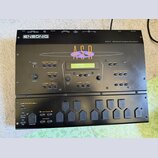 Černý sampler Ensoniq ASR-X Advanced Sampler/Resampler. Zařízení má LCD displej, několik tlačítek a ovládacích prvků s nápisy jako Disk / Global, Eff…