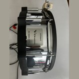 Elektronický snare s chromovaným kovem a černými plastovými prvky. Na boku je vidět stříbrný štítek s nápisy Roland, V-Drums a PD-140DS V-PAD DIGITAL…