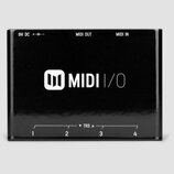 Černý MIDI rozhraní s bílým nápisem MIDI I/O a logem tvořeným dvěma svislými obdélníky v zaobleném čtverci. V horní části jsou nápisy 9V DC + - , MID…
