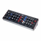 Černý modulární syntetizátor v dřevěném šasi s bílým spodním panelem. Na horním panelu jsou rozděleny sekce s názvy CONTROLLERS, OSCILLATOR BANK, MIX…
