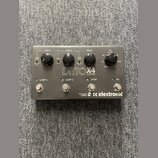 Šedý kytarový pedál s nápisem DITTO X4 LOOPER a logem tc electronic. Zařízení má čtyři stoupací spínače označené jako LOOP 1, LOOP 2, STOP a FX. Na h…