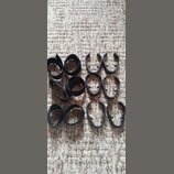 Fotografie zobrazuje deset kusů černých upevňovacích prstenců rozložených na světlém koberci. Šest kusů je vyrobeno z textilní pásky, čtyři kusy jsou…