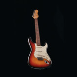Elektrická kytara s trupem v provedení sunburst a bílým pickguardem. Na hlavě hředu je viditelné logo Fender. Nástroj má tři snímače, pět úhlových la…