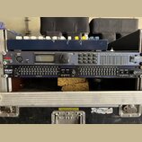 V hliníkovém rackovém kufru jsou namontovány dvě zařízení. Horní přístroj má logo dbx PROFESSIONAL PRODUCTS a nápis DriveRack, obsahuje displej a ovl…