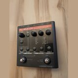Černý efektový pedál s nápisy TC-HELICON a harmony G·XT. Zařízení má čtyři otočné ovladače (Input, Tone, FX, Harmony), přepínač Guitar s výběrem efek…