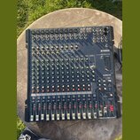 Tmavě modrý mixovací pult značky YAMAHA, model MG166CX USB. Horní část obsahuje vstupní konektory a ovládací prvky, spodní část je vybavena řadou pos…