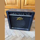 Černý kytarový kombo zesilovač s látkovou přední síťovkou. Na mřížce je žluté logo Peavey a v dolní části nápis BLAZER 158. Horní ovládací panel obsa…