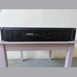 Černý rackový zesilovač s nápisem SAMSON STUDIO AMPLIFIER 85 WATT STEREO SERVO-170. Na předním panelu jsou dvě velké otočné potenciometry, vypínač PO…