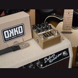 Kytarový efekt pedál zlaté barvy s nápisy GH, GREGORY KILKEN SIGNATURE a ONKO HANDBUILT IN GERMANY. Pedál má pět černých otočných knoflíků s popisky…
