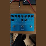 Modrý kytarový efekt s nápisem REFLECTING POOL a logem Fender. Zařízení má tři spínací tlačítka označená jako REVERB, TAP a DELAY. Na pravé straně se…