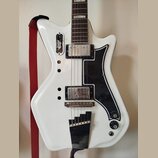 Bílá elektrická kytara s černým plechtrátem. Na těle jsou dva humbuckery, jedna tónová klika a dvě potenciometry s nápisy Volume a Tone. V horní část…