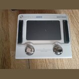 Bílý efektový procesor s černým displejem. V horní části je nápis AMPERO MINI Amp Modeler / Effects Processor a logo HOTONE. Dole jsou dvě kovové kon…