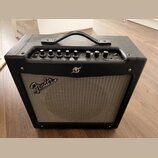 Černý kytarový kombo zesilovač s šedou síťovkou. Na přední straně je viditelné logo Fender a nápis MUSTANG LT. Horní ovládací panel obsahuje několik…