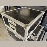Černý transportní case s hliníkovými hranami a kovovými rohy. Na přední straně je nalepená bílá nálepka s modrým logem a nápisem servis, pod kterým j…