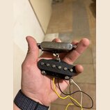 Fotografie zachycuje dva elektrické kytarové snímače držené v dlani. Horní snímač je typu humbucker s chromovaným krytem, spodní je jednoduchý snímač…