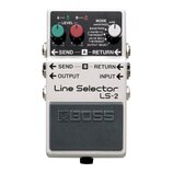 Kytarový pedál značky BOSS, model Line Selector LS-2. Zařízení má stříbrné kovové šasi s černým vypínacím pedálem, na kterém je vyražené logo BOSS. N…