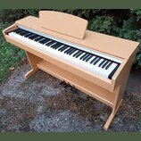 Digitální piano v dřevěné barvě s klasickým provedením. Nástroj má bílé a černé klávesy, tři sustain pedály a nápis "KORG" na horním víku. Povrch nás…