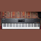 Černý digitální klavír s bílými a černými klávesami. Na levé straně je nápis studiologic a na pravé straně numaxPIANO. Horní panel obsahuje displej,…