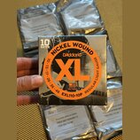 Krabice s nápisem 10 SETS obsahuje kytarové struny D'Addario XL Nickel Wound v provedení Regular Light Gauge. Na obalu je uveden kód EXL110-10P, rozm…