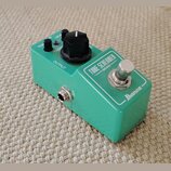 Zelený kytarový efekt pedál značky Ibanez s nápisem TUBE SCREAMER MINI. Na horní straně jsou tři černé ovládací knoflíky s popisky TON, OVERDRIVE a L…