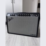 Kytarový zesilovač s černým krytím a šedou tkanou mřížkou. Na horním ovládacím panelu jsou knoflíky a nápisy NORMAL, VIBRATO, VOLUME, TREBLE, BASS, R…