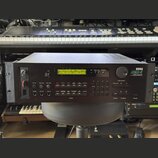 Černý rackový syntetizátor s nápisem KORG DSM-7 DIGITAL SAMPLING SYNTHESIZER MODULE. Přístroj má v horní části zelený LCD displej s textem CMB01:POWE…