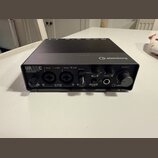 Černý audio rozhraní s nápisem UR22C AUDIO INTERFACE 32-bit/192Hz a logem steinberg. Na přední straně jsou dva kombinované vstupy D-PRE MIC/LINE, ovl…